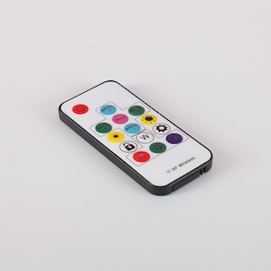 May include: A black remote control with a white face and 13 buttons. The buttons are labeled with various symbols, including a power button, a speed button, a mode button, and a lock button. The remote control also has a small antenna and the text "RF Wireless".