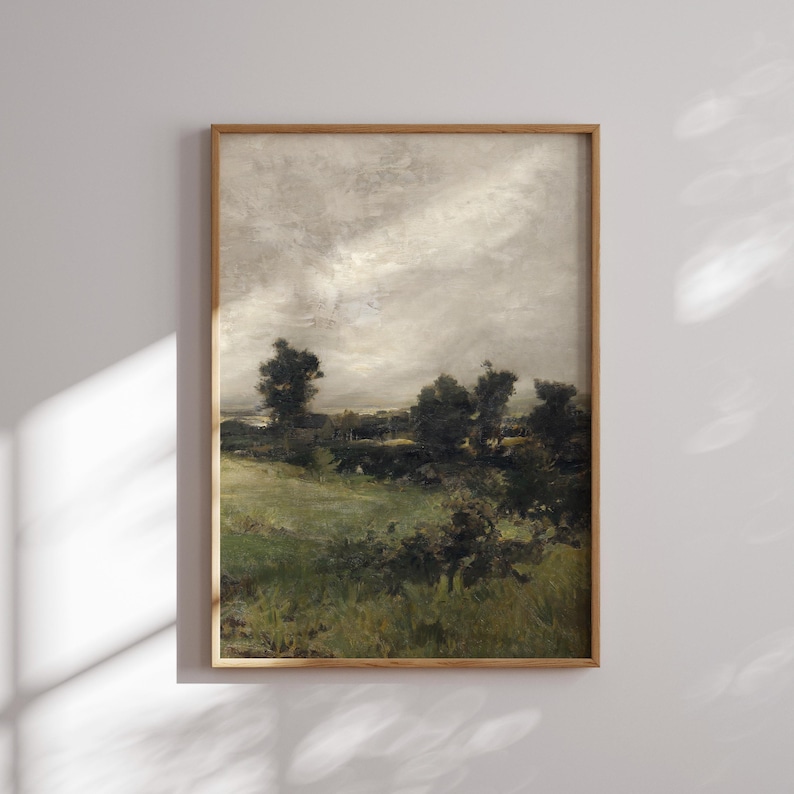 May include: A framed landscape painting depicting a field of green grass with a line of trees in the background. The sky is a light gray with a few clouds.