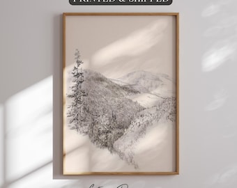 Könnte beinhalten: Ein gerahmter Schwarz-Weiß-Druck einer schneebedeckten Berglandschaft. Das Kunstwerk zeigt eine detaillierte Bleistiftzeichnung eines schneebedeckten Bergkamms und eines hohen Nadelbaums. Der Text "PRINTED & SHIPPED" steht oben und "Gate of Design Studio" unten.