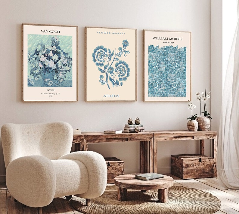 Op de afbeelding: Drie ingelijste kunstprints met bloemmotieven. De linker print toont een blauw en wit stilleven met rozen met de tekst "Van Gogh, Roses, The National Gallery of Art, 1890". De middelste print toont een blauw en wit bloemmotief met de tekst "Flower Market, Athens". De rechter print toont een blauw en wit bloemmotief met de tekst "William Morris, Marigold".