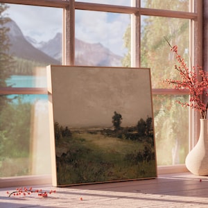 May include: A framed landscape painting with a muted color palette, featuring a field, trees, and a cloudy sky. The artwork is displayed on a wooden windowsill, with a vase of red berries and a scenic mountain view visible through the window.