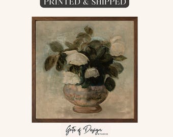 May include: A framed floral still life painting featuring white roses in a vase. The artwork has a vintage aesthetic with a muted color palette of greens, browns, and creams. The text "PRINTED & SHIPPED" is at the top.