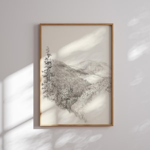 以下が含まれることがあります： 前景に一本の木が描かれた、白黒の鉛筆画の山脈。絵は明るい木製の額縁に入っています。