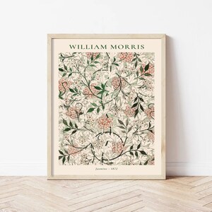 May include: A framed print of a floral pattern by William Morris, titled "Jasmine - 1872". The design features a repeating pattern of white flowers, green leaves, and orange-red berries on a cream background.