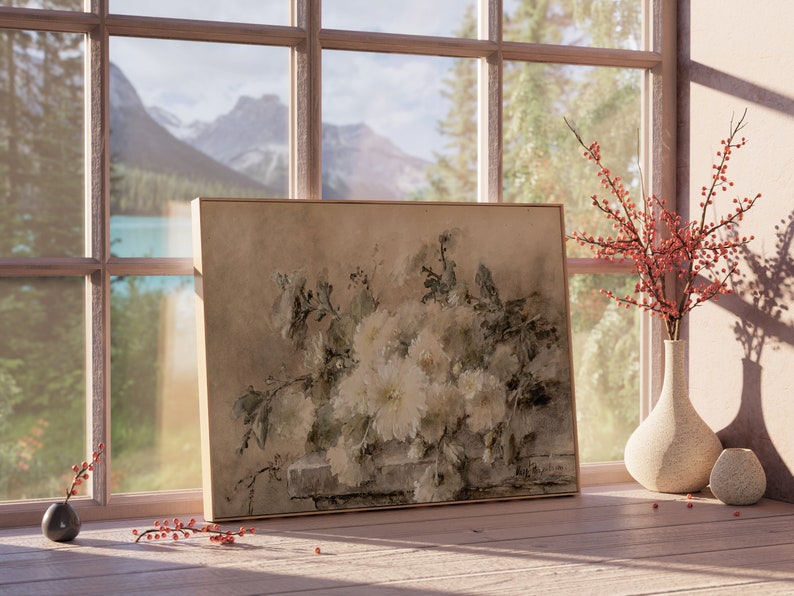 May include: A framed painting of a bouquet of white flowers with green leaves, set against a backdrop of a mountain landscape seen through a window. The painting is on a wooden table with a vase of red berries and a small vase.