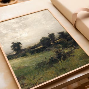 May include: A framed painting of a landscape with a field of green grass, trees, and a cloudy sky. The painting is in a light wood frame.