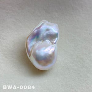May include: A large, irregular, white baroque pearl with iridescent hues. The pearl has a smooth, glossy surface and an organic, asymmetrical shape.