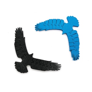 Könnte beinhalten: Zwei hölzerne Vogelschnitte, einer schwarz und einer blau, die sich in einem Kreis anordnen.