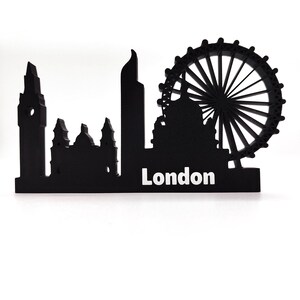 May include: Black silhouette of the London skyline, including Big Ben, the London Eye, and other buildings. The word "London" is written in white below the skyline.