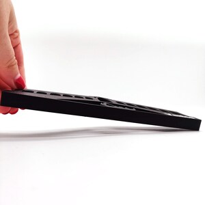May include: A black plastic storage tray with multiple compartments. The tray is designed to hold small items, such as jewellery, craft supplies, or tools.