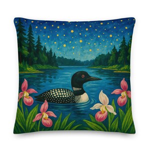 Puede incluir: Cojín cuadrado con una pintura de un somorgujo nadando en un lago bajo un cielo estrellado. Flores rosas y blancas y follaje verde enmarcan el agua. El somorgujo tiene marcas en blanco y negro.