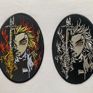 May include: Two black oval embroidered patches with white and gold thread. The left patch features a character with red eyes and yellow hair with flames behind them. The right patch features a character with red eyes and white hair with white flames behind them.