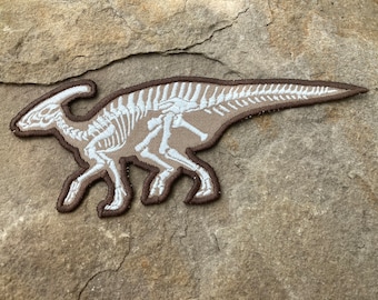 Iron patch with a print of a famous dinosaur Parasaurolophus with bones which are glowing in the dark  7.5” x 3.1”