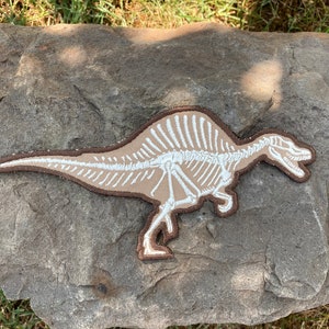 Parche termoadhesivo de Spinosaurus: Huesos de dinosaurio que brillan en la oscuridad (19 x 8,6 cm)