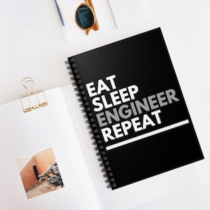 May include: Black spiral bound notebook with white text that reads "Eat Sleep Engineer Repeat".