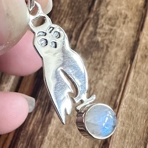 May include: Silver owl pendant with a round moonstone charm. The owl has detailed eyes and wings.