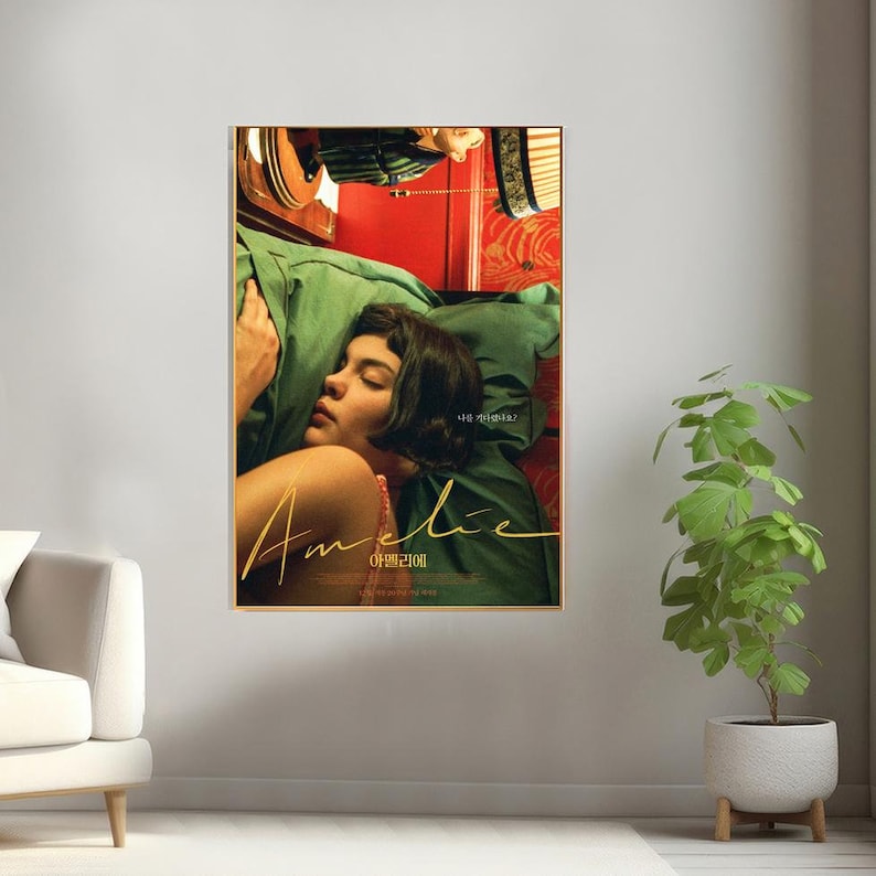 May include: A movie poster for the film "Am&eacute;lie", featuring a woman sleeping in a bed with a red and green patterned headboard. The title of the film is written in cursive in gold lettering, with the Korean translation below. The text "나 처음이야?" is also visible in the poster.