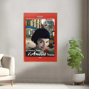 May include: A red movie poster with a cartoon image of a Parisian street scene. The poster features a woman with short black hair looking directly at the viewer. The title of the movie is "Le Fabuleux Destin d'Am&eacute;lie Poulain".