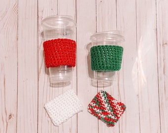 May include: Two clear plastic cups with red and green crocheted sleeves, along with two crocheted coasters. One coaster is white, and the other is red, green, and white striped. The items are arranged on a light wood-grain surface.