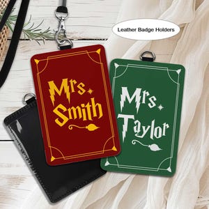 May include: Leather badge holders with the names "Mrs. Smith" and "Mrs. Taylor" in a stylized font. The "Mrs. Smith" badge is red with yellow text, and the "Mrs. Taylor" badge is green with white text. A black lanyard is attached.