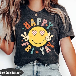 May include: Dark gray heather t-shirt with a colorful graphic of a smiley face with peace signs and the text "Happy Fri-yay".