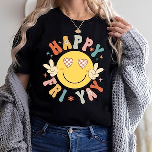 May include: A black t-shirt with a colorful graphic of a smiley face with heart eyes and the text "Happy Fri-yay".