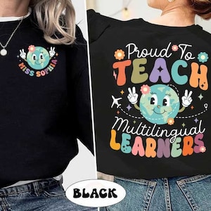 May include: Black sweatshirt with a colorful graphic of a smiling earth with the text "Proud to Teach Multilingual Learners".