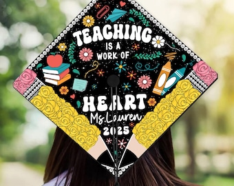 May include: Black graduation cap with a colorful design featuring the text "Teaching is a work of heart" and the name "Ms. Lauren" with the year "2025".