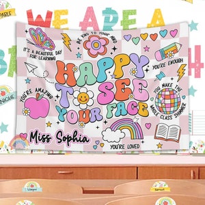 Peut inclure: Une banni&egrave;re de classe &agrave; carreaux rose et blancs avec le texte "We Are A Happy To See Your Face" en police r&eacute;tro color&eacute;e. La banni&egrave;re comprend &eacute;galement diverses illustrations color&eacute;es, notamment un arc-en-ciel, un papillon, une fleur, un crayon, une pomme, une boule disco et un livre. Le texte "Miss Sophia" est &eacute;crit dans un c&oelig;ur rose au bas de la banni&egrave;re.