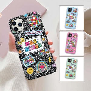 May include: A black and white phone case with a notebook paper design, featuring colorful stickers with text like "You're Amazing" and "Mrs. Wilson." Additional cases in blue, pink, and green with glitter and names.