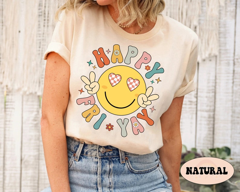 May include: A cream colored t-shirt with a retro smiley face graphic that says "Happy Fri-yay". The smiley face has checkered hearts for eyes and peace signs for hands.