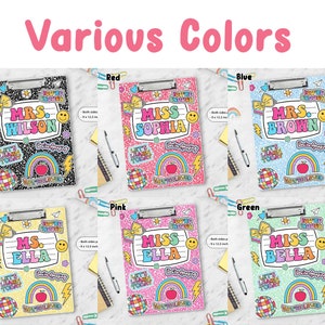 Puede incluir: Seis portapapeles en negro, rojo, azul, amarillo, rosa y verde, cada uno con un clip de metal y pegatinas coloridas que incluyen un arco&iacute;ris, una manzana, una bola de discoteca y textos como 'You're Enough' y 'Let's Learn Today'.