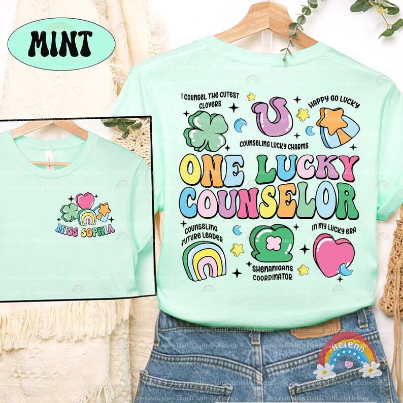 Puede incluir: Una camiseta verde claro con un dise&ntilde;o gr&aacute;fico colorido que dice "One Lucky Counselor". El dise&ntilde;o incluye tr&eacute;boles, arco&iacute;ris, corazones y estrellas. El texto "Miss Sophia" est&aacute; en la parte delantera de la camiseta.