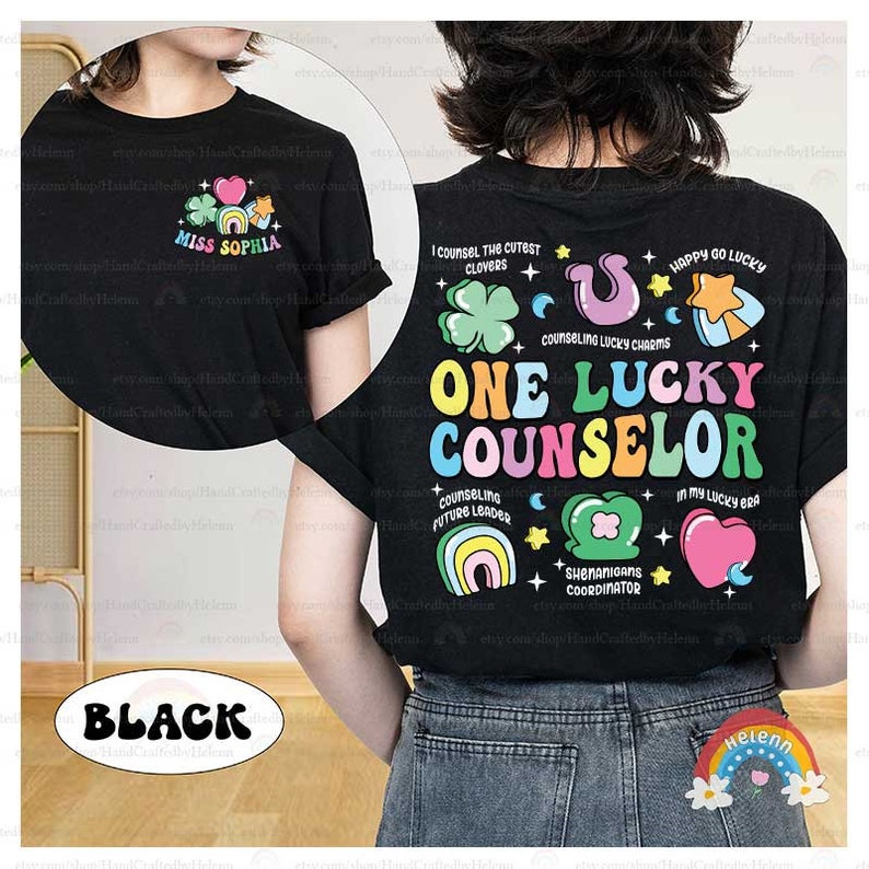 Puede incluir: Camiseta negra con un dise&ntilde;o de arco&iacute;ris que dice "One Lucky Counselor". El dise&ntilde;o incluye tr&eacute;boles, estrellas, arco&iacute;ris y corazones. El texto "Miss Sophia" est&aacute; en la parte delantera de la camiseta.