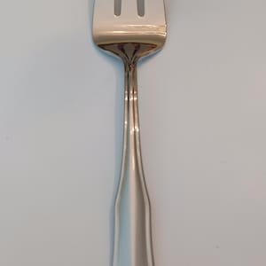 May include: A silver-colored fork with three tines. The handle has a flared, decorative design. The fork is made of a shiny, reflective metal, likely stainless steel. This utensil is suitable for formal dining.