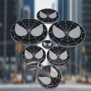 K&ouml;nnte beinhalten: Ein Set aus sechs schwarzen und wei&szlig;en Schl&uuml;sselanh&auml;ngern aus Metall mit einem Spider-Man-Design. Die Schl&uuml;sselanh&auml;nger sind rund und haben ein schwarzes Netzdesign mit einem wei&szlig;en Spider-Man-Gesicht in der Mitte. Die Schl&uuml;sselanh&auml;nger sind an einem silbernen Ring befestigt.