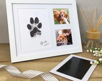 May include: White frame with a black paw print, the name "Harvey" and the date "15.07.23" written below. Two photos are in the frame, one of a dog and one of a person holding the dog.