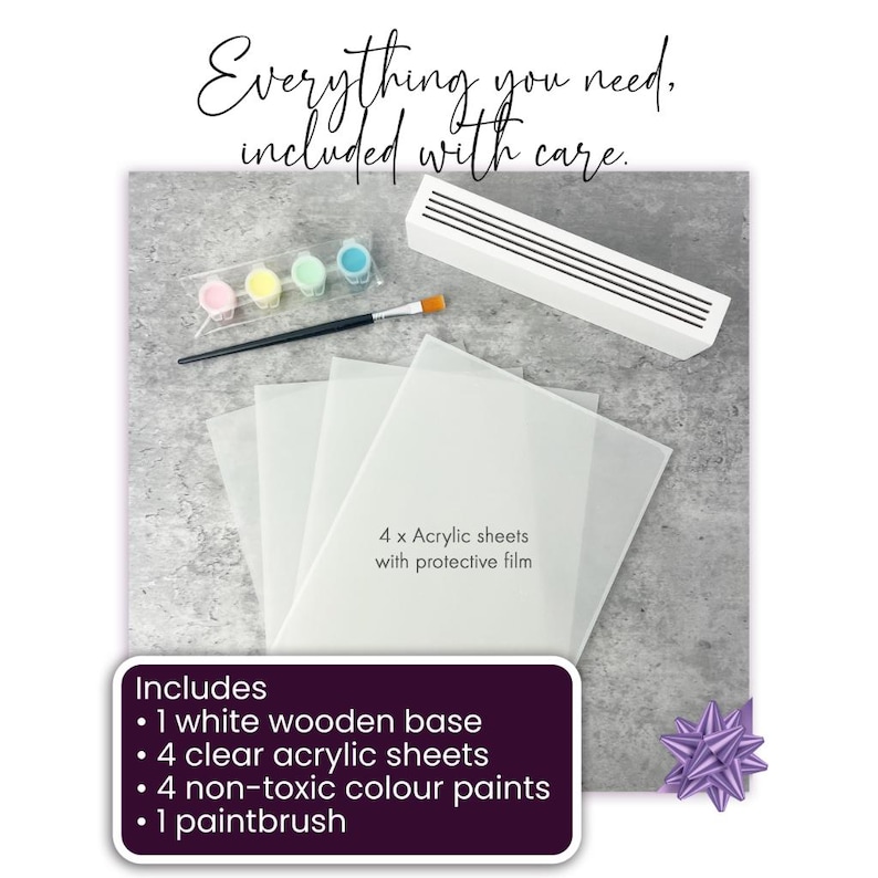 May include: A craft kit with a white wooden base, four clear acrylic sheets, four non-toxic color paints, and a paintbrush. The kit includes a white rectangular object, a paintbrush, and small containers of pink, yellow, green, and blue paint. Text reads "Everything you need, included with care."