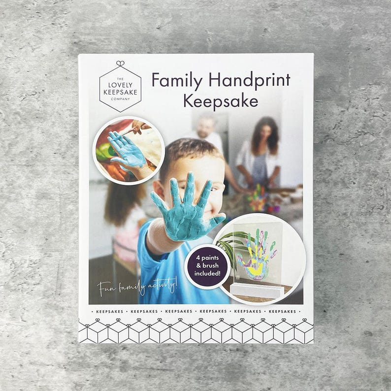 May include: A white Family Handprint Keepsake kit with the text "The Lovely Keepsake Company." The kit includes 4 paints and a brush. A child's hand is covered in blue paint, and the words "Fun family activity!" are written on the front.
