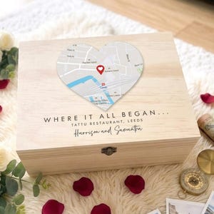 Può includere: Una scatola di legno color chiaro con un design a forma di cuore. La mappa mostra una posizione a Leeds, con un indicatore rosso. Il testo sulla scatola recita "WHERE IT ALL BEGAN..." e i nomi "Harrison and Samantha".