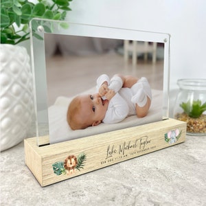 May include: A wooden photo frame with a clear acrylic insert. The frame features a lion and elephant illustration with green leaves. The text on the frame reads "Luke Michael Taylor 8lb 5oz 11:12 AM, 10th December 2023".