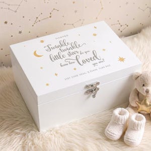 Peut inclure: Un coffret souvenir en bois blanc avec un fermoir argenté, décoré d'étoiles dorées et du texte "Twinkle twinkle little star do you know how loved you are ?" Comprend des chaussons et un ours en peluche.