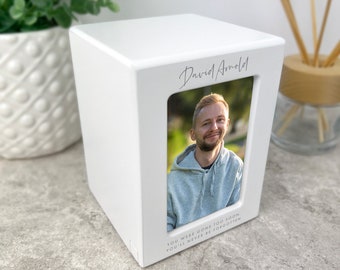 May include: White wooden box with a photo of a man and the text "David Arnold" and "You were gone too soon, you'll never be forgotten".