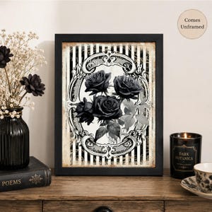 Pu&ograve; includere: Una stampa artistica da parete rettangolare con un'illustrazione in bianco e nero di tre rose all'interno di una cornice ovale decorata su uno sfondo a righe verticali. La stampa &egrave; inserita in una cornice nera con il testo Comes Unframed.