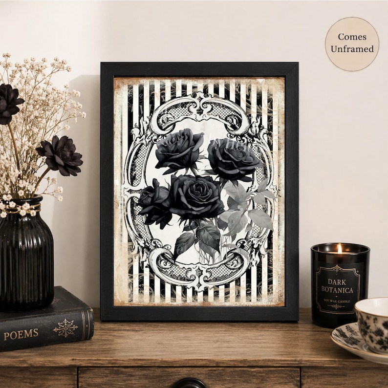 Pu&ograve; includere: Una stampa artistica da parete rettangolare con un'illustrazione in bianco e nero di tre rose all'interno di una cornice ovale decorata su uno sfondo a righe verticali. La stampa &egrave; inserita in una cornice nera con il testo Comes Unframed.