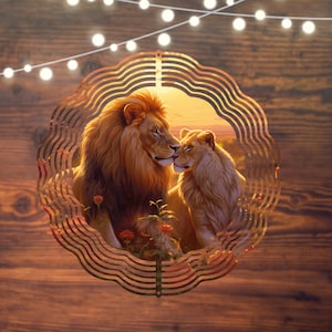 May include: A metal wind chime featuring a pair of lions with a sunset background. The lions are facing each other and appear to be nuzzling. The wind chime is made of metal and has a circular shape.