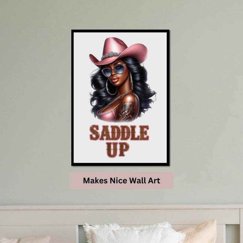 May include: A digital art print featuring a woman with dark hair wearing a pink cowboy hat and sunglasses. The text "Saddle Up" is printed below the woman in brown letters.
