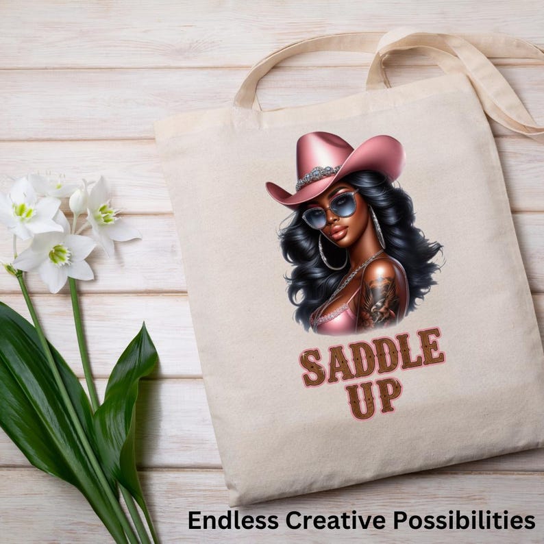 May include: A white tote bag with a pink cowboy hat and sunglasses. The image features a woman with long black hair and the text "Saddle Up".