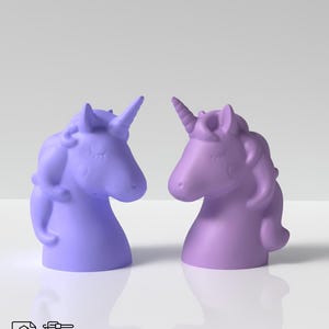 Könnte beinhalten: Zwei 3D-gedruckte Einhornkopf-Figuren. Eine ist hellblau und die andere ist helllila. Sie schauen sich an.