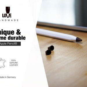 K&ouml;nnte beinhalten: Ein wei&szlig;er Eingabestift mit dunkelbrauner Spitze auf einer Holzoberfl&auml;che neben zwei kleinen dunkelbraunen Lederkappen. Der Text auf dem Bild lautet: LOVE HANDMADE, Unique & extreme durable for Apple Pencil, 100% GENUINE LEATHER, Made in Germany.